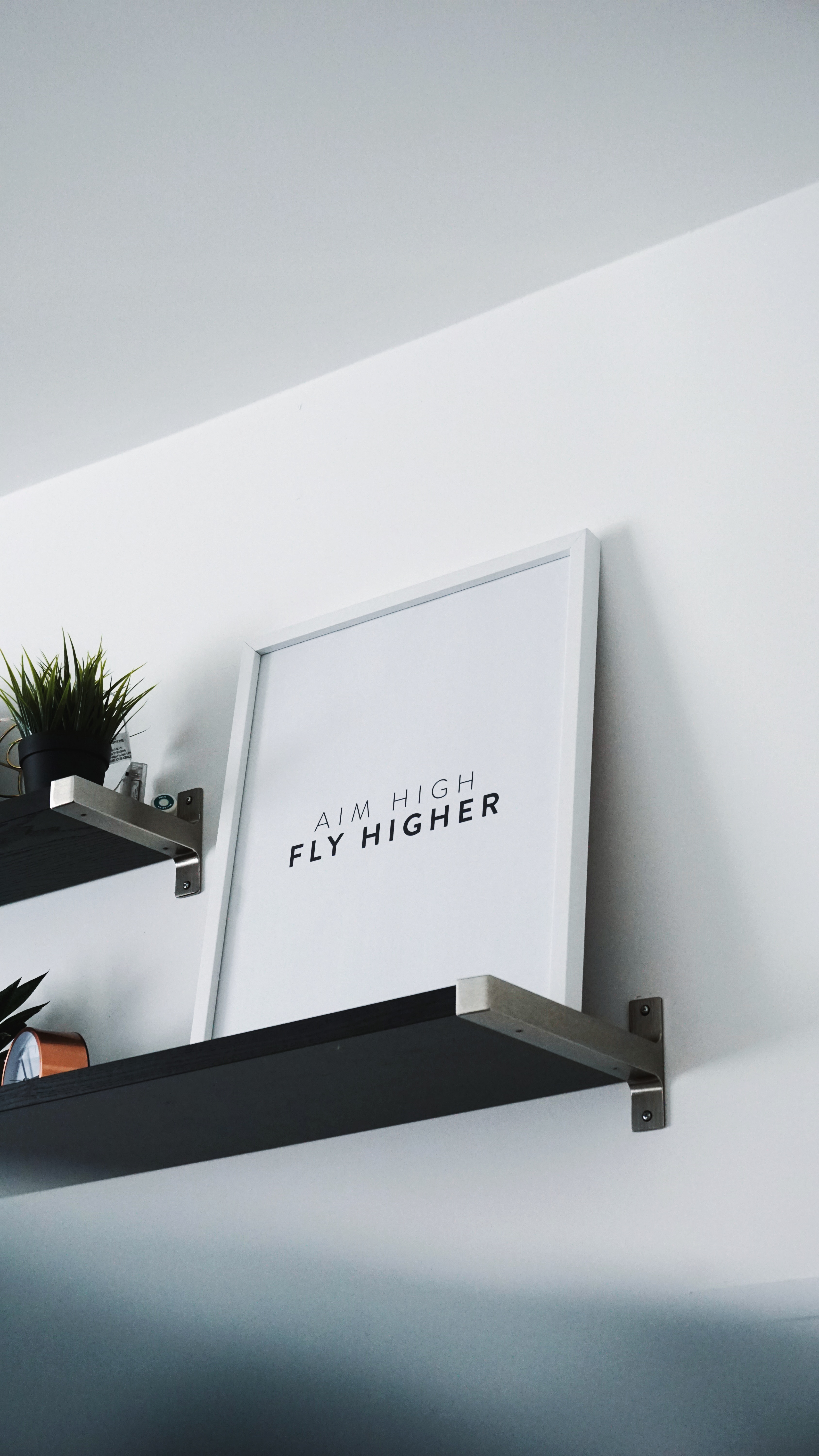 Image of wall art that says Aim High Fly Higher; Photo by James Healy on Unsplash